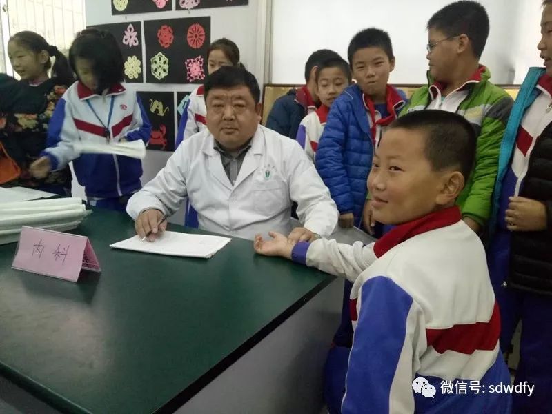 孙以民在为学校的学生进行查体服务